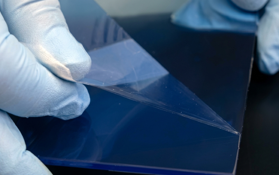 Rimozione del film protettivo da una lastra di acrilico prima della stampa UV su plexiglass